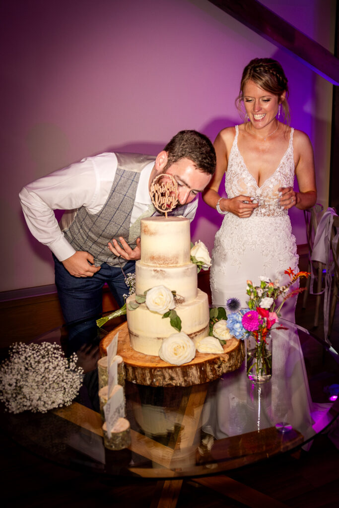 Groom eating wedding cake made by Danni McKenzie.