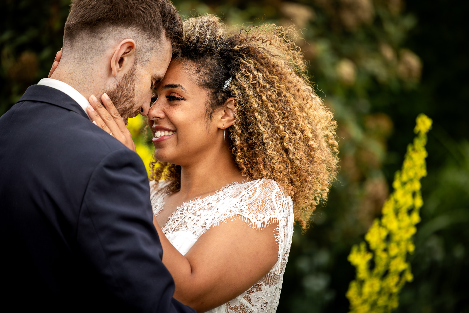 Bride and groom posing in a garden.