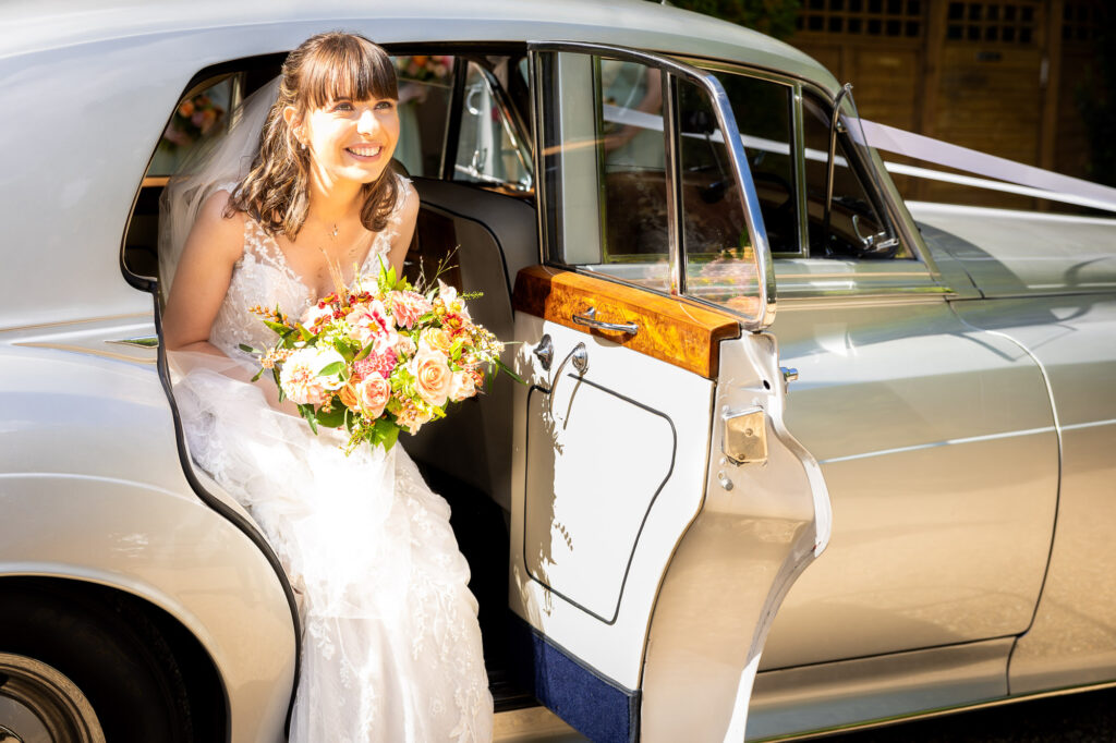 A bride stepping out of her wedding car.