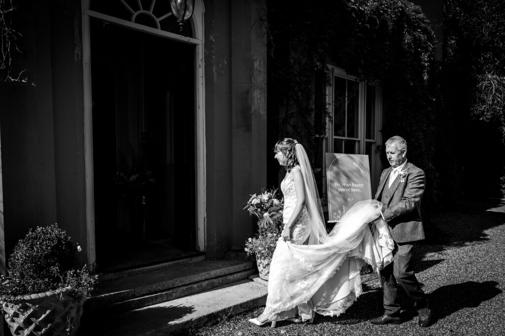 Father of the bride carrying the bride's train.