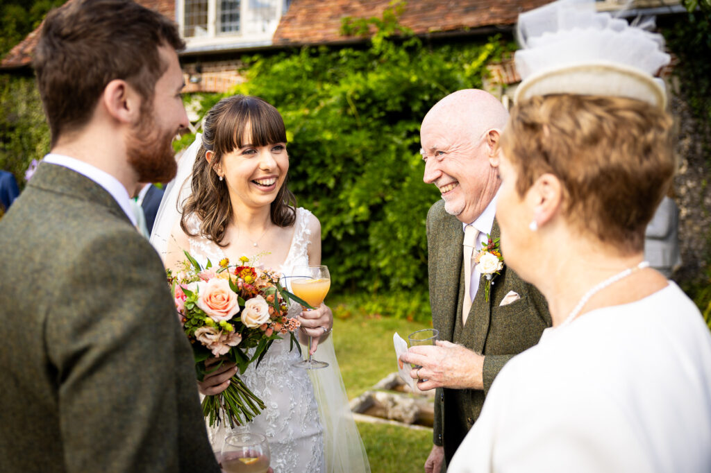 Wedding guests laughing during drinks reception.