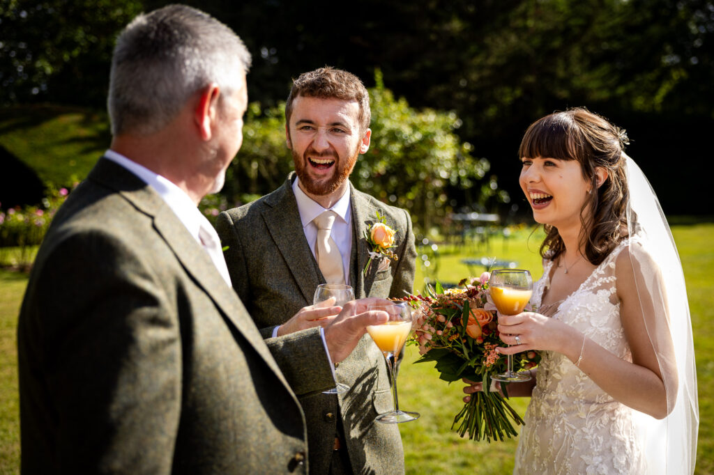 Bride and groom laughing during drinks reception.