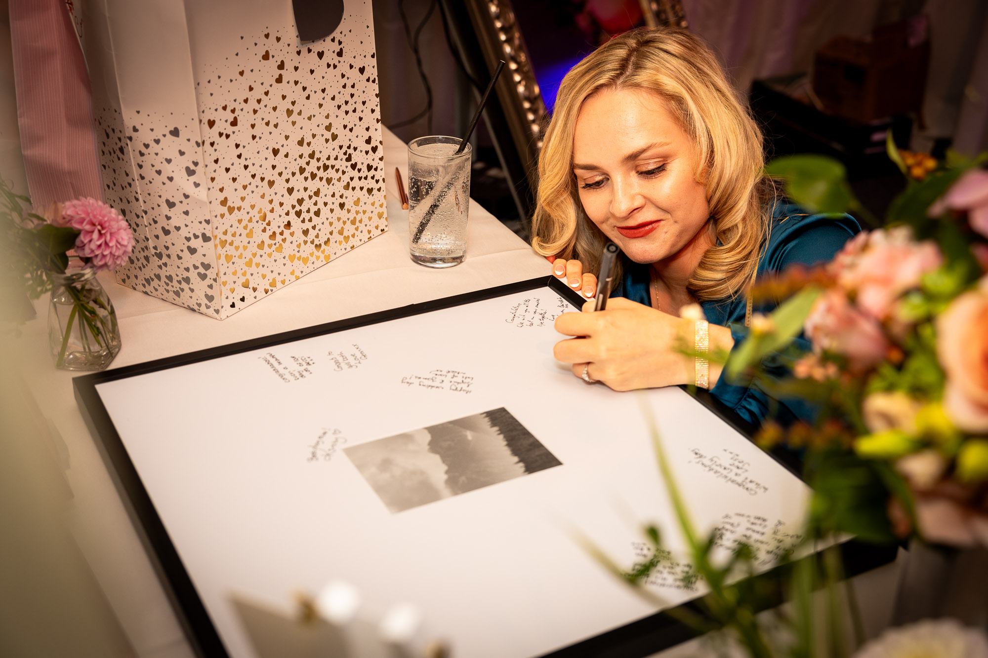 A wedding guest signing the guest book.