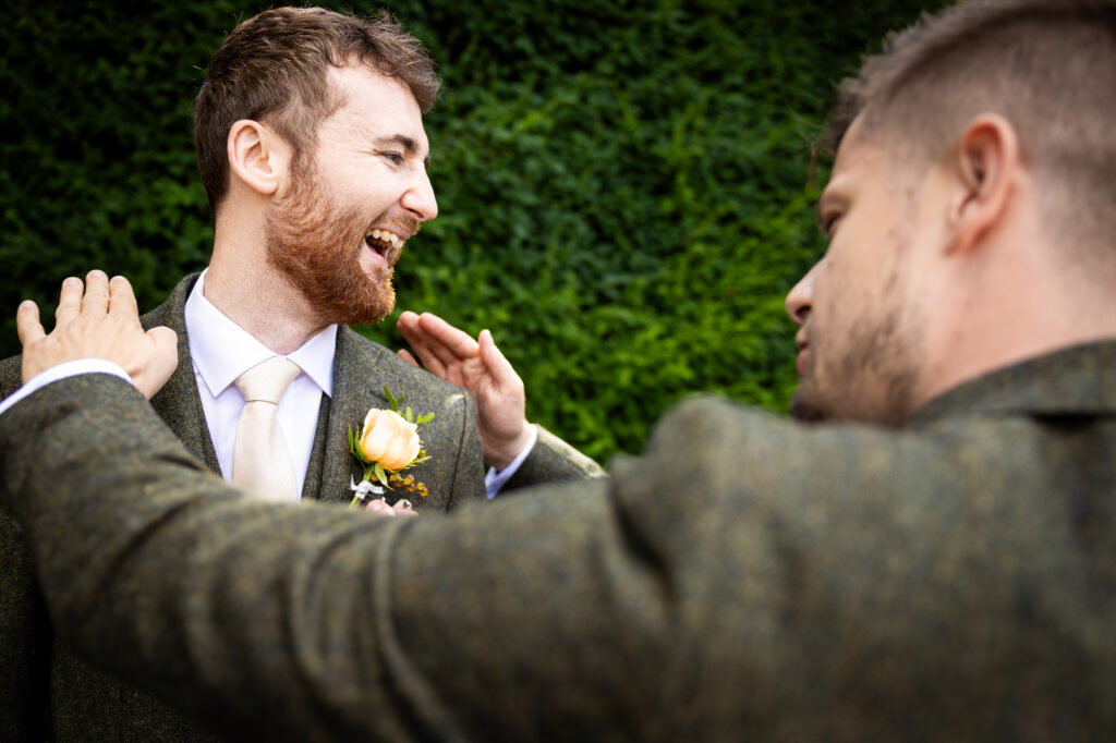 Groom laughing with his best man.